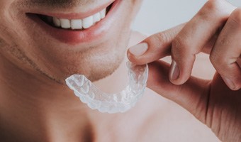 A man holding a transparent mouthguard 
