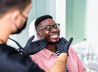 Dentist looking at patient's smile in treatment room