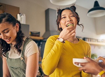 Group of friends smiling while eating together