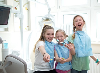 Children smiling while visiting a Prince Albert family dentist