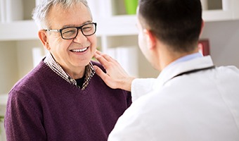 Older man smiling at his Prince Albert implant dentist