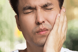 man holding jaw in pain