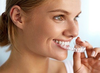 woman putting on invisalign