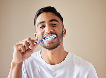 a man brushing his teeth at home