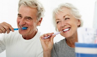 A senior couple brushing their teeth in the bathroom