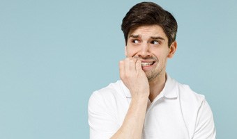 A young man biting his nails 