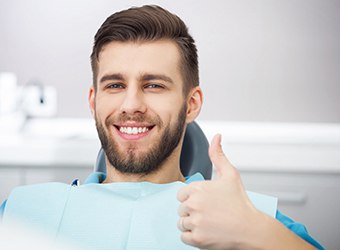 Bearded male dental patient giving a thumbs up