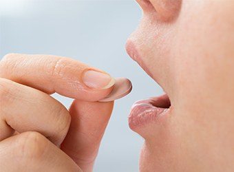 woman taking oral sedation pill