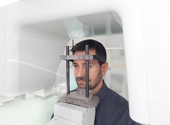 Man positioned in CBCT machine, ready for scan