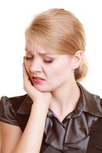 Toothache. Young woman suffering from tooth pain isolated