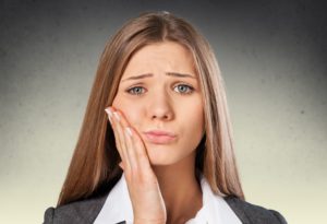 A woman touching her mouth in pain