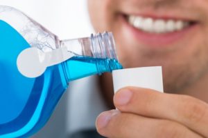 Dentist pouring antimicrobial mouthwash as dental patient safety protocol COVID-19