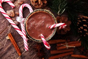 Mug of hot chocolate surrounded by candy canes