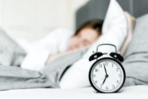 Alarm clock next to sleeping woman