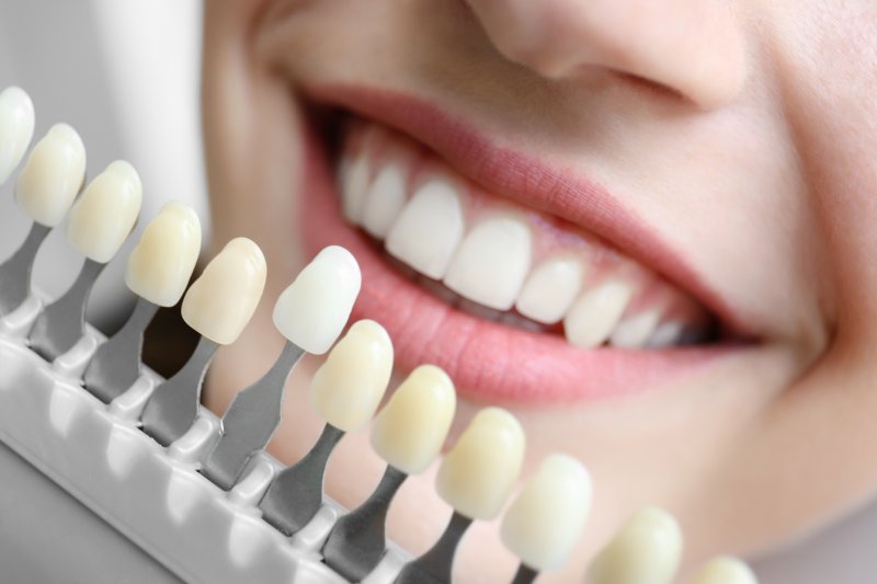 Woman selecting tooth color for cosmetic dentistry