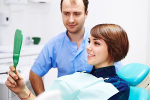 Woman in dental chair looking in mirror