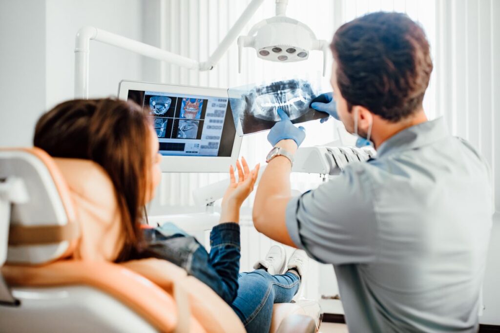 A dentist reviewing X-rays with a patient